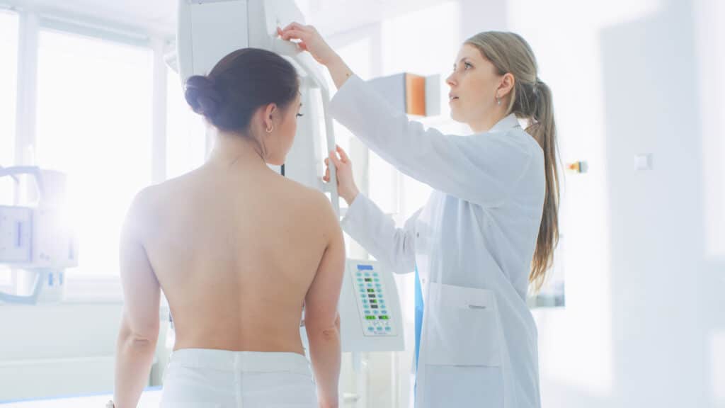 Topless woman having a consultation with her doctor about veins on her chest
