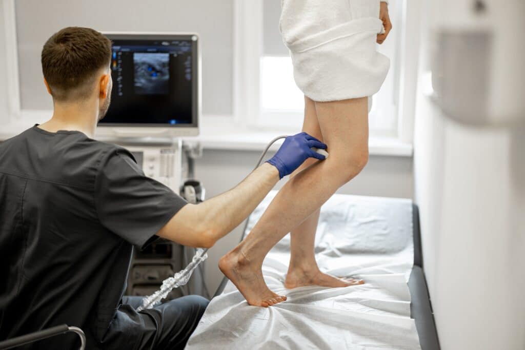 Ultrasound technician scanning a patient's varicose veins in preparation for Ultrasound-guided sclerotherapy